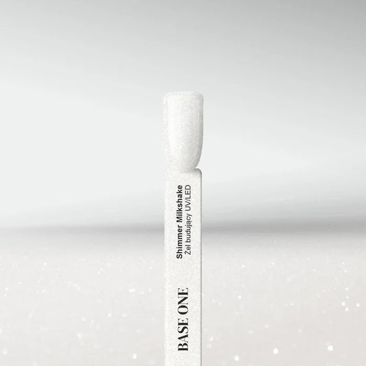 Swatch of Base One Shimmer Milkshake UV/LED builder gel, featuring a semi-transparent milky white finish with fine silver glitter particles on a nail tip.
