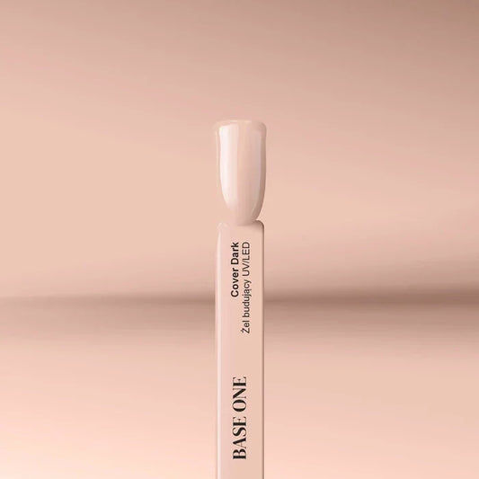 Applying the self-leveling Base One Cover Dark UV building gel (15g) onto a clear nail tip for a deep beige nail extension.