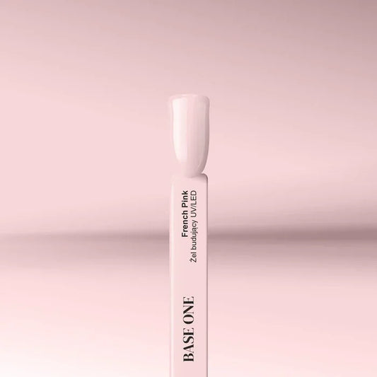 Cured nail tip displaying the classic pink shade of the Base One French Pink UV builder gel (15g), used to sculpt a natural French manicure nail bed.