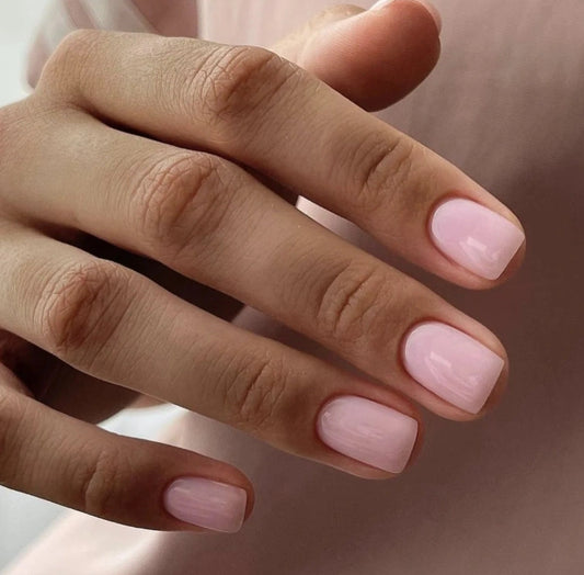 Close-up of a natural manicure created with Silcare Brush One Rose Rebel bottle UV gel, featuring glossy soft pink BIAB nails in a short square shape, ideal for natural nail overlays, strengthening, salon-quality manicures and elegant everyday wear.