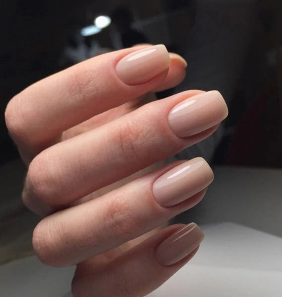 Nails finished with Base One Brush One Bottle Gel (15g) in Naked Ambition, showing a smooth, subtle beige-pink manicure perfect for a refined look.