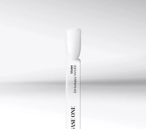Cured nail tip displaying the transparent, high-gloss finish of the Base One Violet UV building gel (15g), used to prevent yellowing.