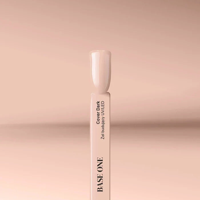 Applying the self-leveling Base One Cover Dark UV building gel (15g) onto a clear nail tip for a deep beige nail extension.