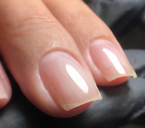 Nails finished with a clear overlay of High Light LED Blue Builder Gel, showcasing a transparent, strengthened look with neutralized yellow tones.