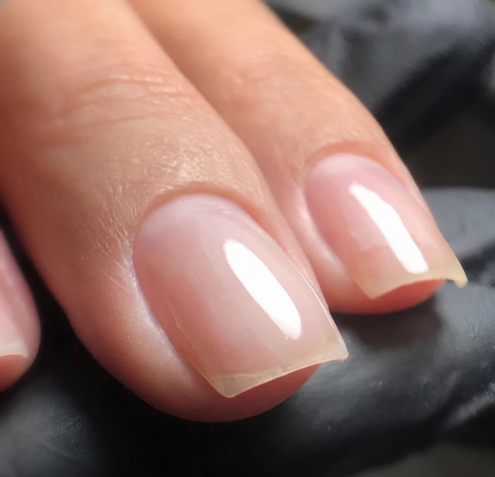 Nails finished with a clear overlay of High Light LED Blue Builder Gel, showcasing a transparent, strengthened look with neutralized yellow tones.