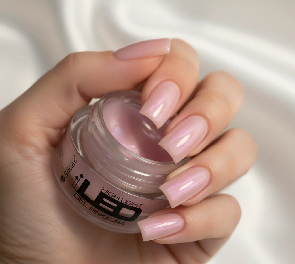 Hand with a full coverage manicure using the High Light LED Aura Pink Builder Gel, holding the product jar to showcase the final pink pearl effect.