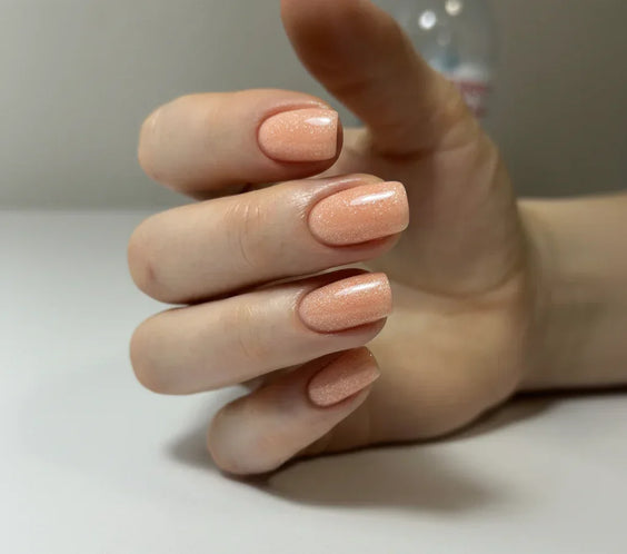 Nails finished with Base One Shimmer Blush Cream UV builder gel (15g), displaying a smooth, natural beige manicure with elegant, subtle shimmer particles.