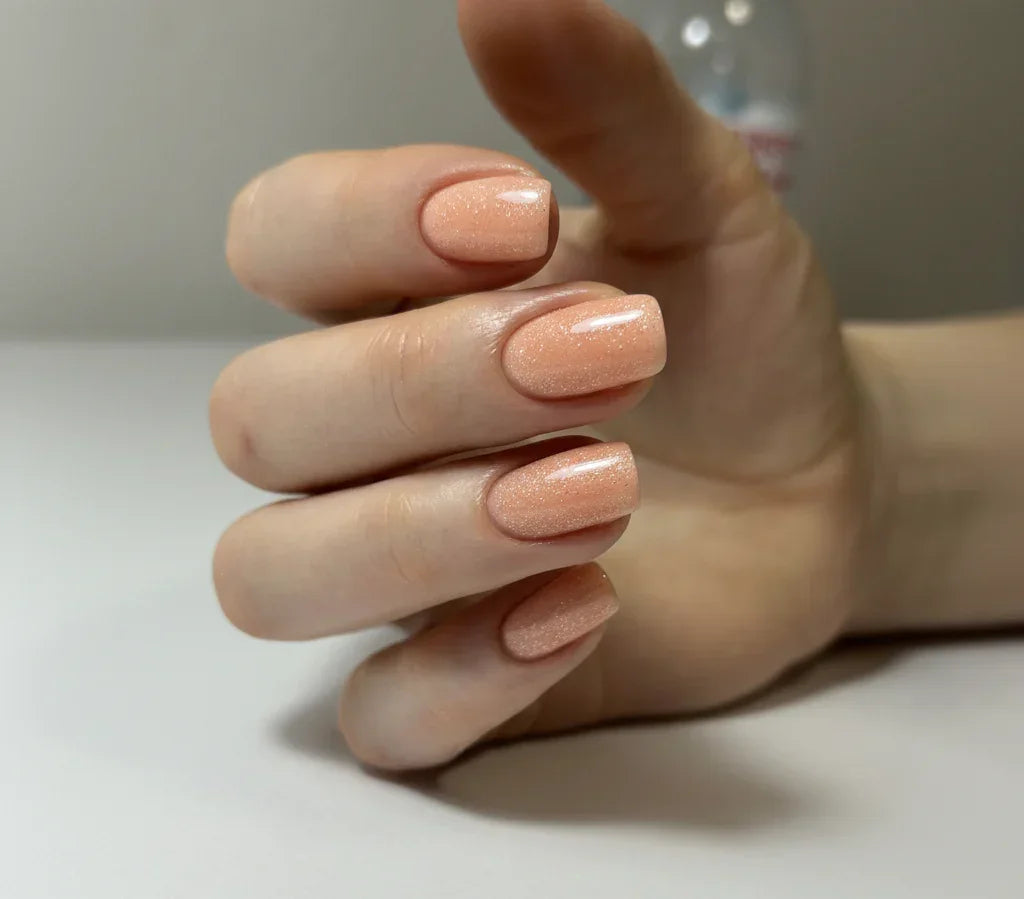 Nails finished with Base One Shimmer Blush Cream UV builder gel (15g), displaying a smooth, natural beige manicure with elegant, subtle shimmer particles.