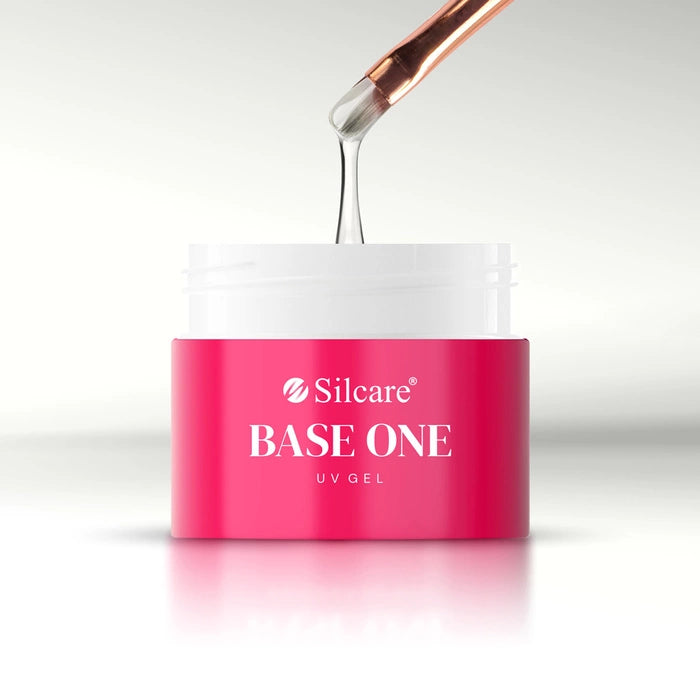 An open pink jar showing the medium-thick white consistency of French White Marble UV/LED builder gel on a brush by Silcare.