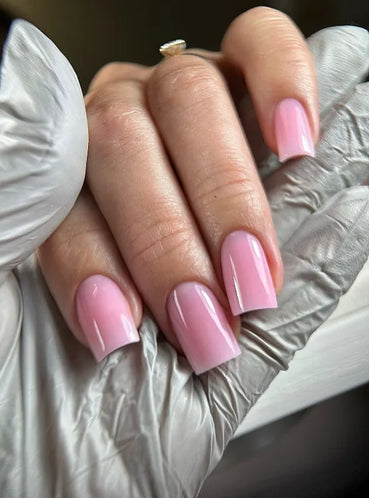 Close-up of glossy square-shaped nails finished with Silcare 10in1 Revolution Light Pink builder base gel. Soft pastel light pink BIAB-style manicure on natural nails with a smooth, high-shine finish, ideal for strengthening nails, overlays, and long-lasting gel manicures.