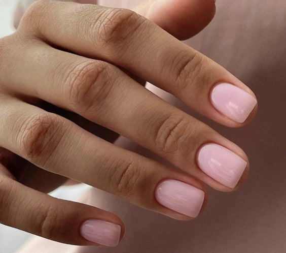 Close-up of a natural manicure created with Silcare Brush One Rose Rebel bottle UV gel, featuring glossy soft pink BIAB nails in a short square shape, ideal for natural nail overlays, strengthening, salon-quality manicures and elegant everyday wear.