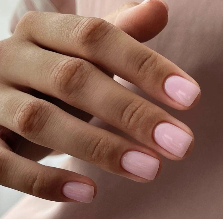 Close-up of a natural manicure created with Silcare Brush One Rose Rebel bottle UV gel, featuring glossy soft pink BIAB nails in a short square shape, ideal for natural nail overlays, strengthening, salon-quality manicures and elegant everyday wear.