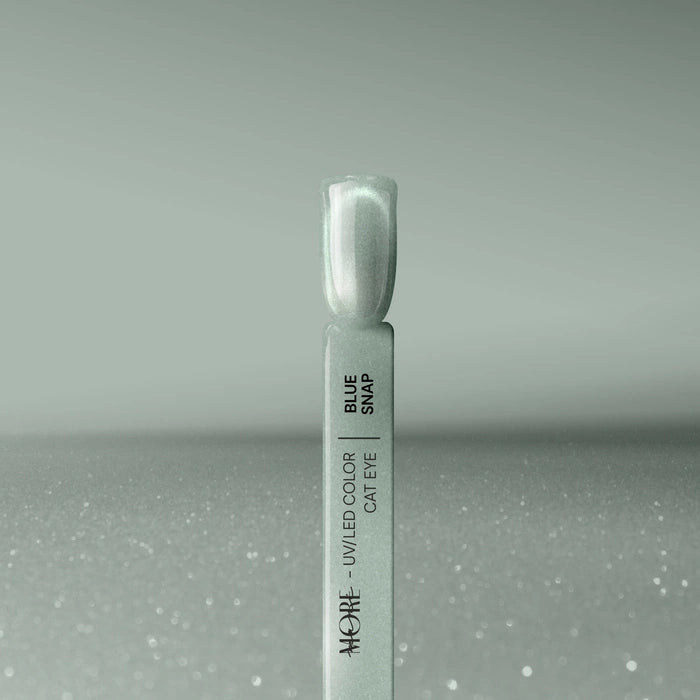 Silcare maniMORE Cat Eye Blue Snap swatch showing the shimmering magnetic teal finish on a display tip against a soft sparkling background.