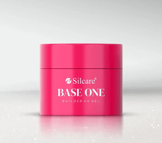 A bright pink jar of Silcare Base One Builder UV Gel in the shade Milkshake, centred against a soft grey, sparkling background for professional nail enhancement—by Silcare.