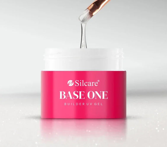 Silcare Base One Builder UV Gel in Shimmer Milkshake, a semi-transparent milky white builder gel with fine glitter being lifted from the jar with a nail brush.