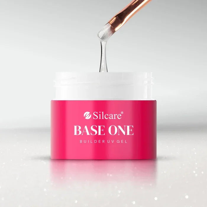 Silcare Base One Builder UV Gel in Shimmer Milkshake, a semi-transparent milky white builder gel with fine glitter being lifted from the jar with a nail brush.