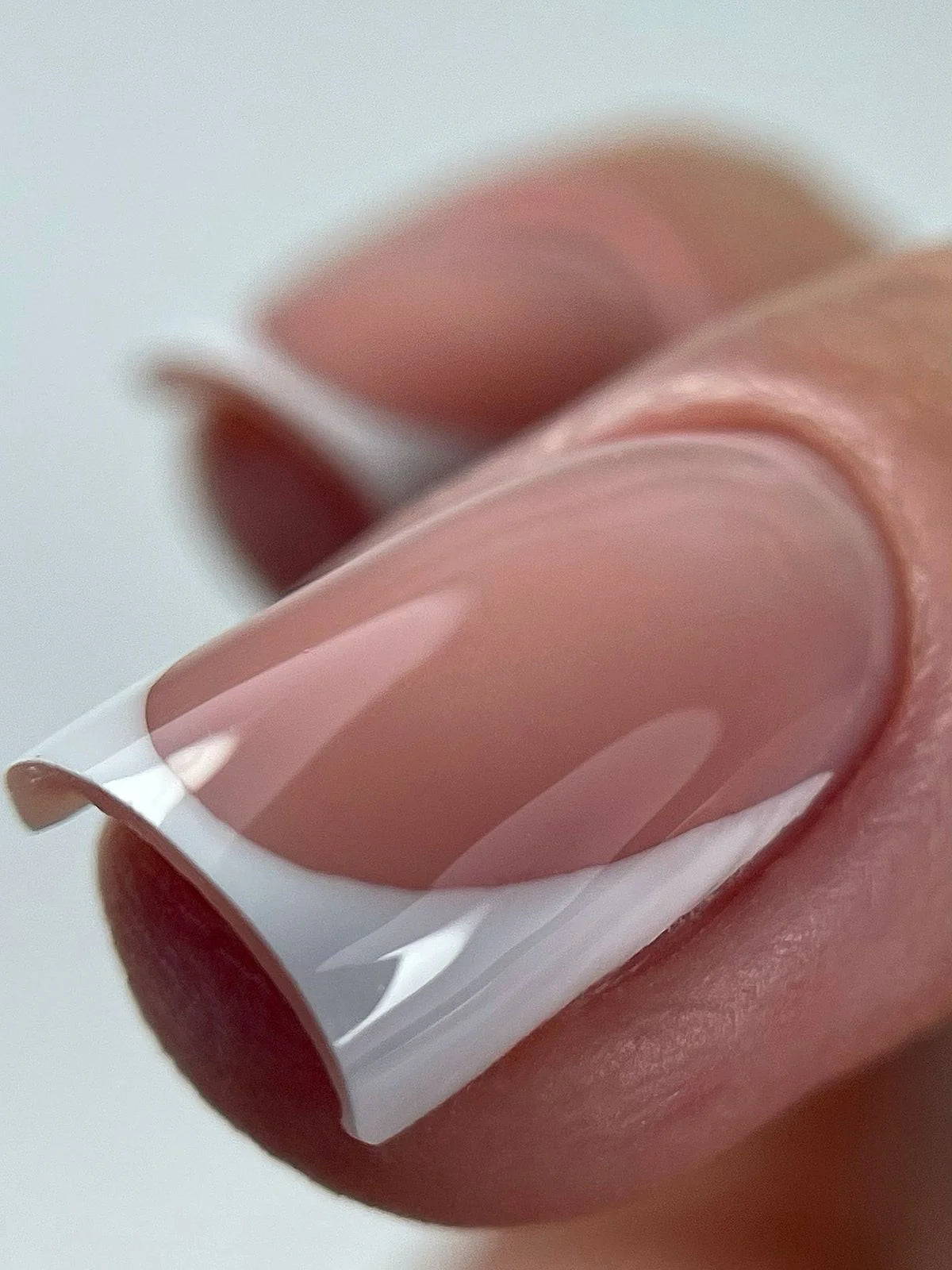 Close-up of a square-shaped French manicure featuring a crisp white tip and a soft pink marble base using Silcare professional nail products.