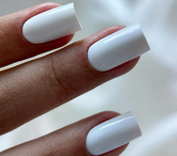 A close-up view of a professional square manicure featuring the opaque white Silcare Base One French White Opal UV builder gel shade by Silcare.