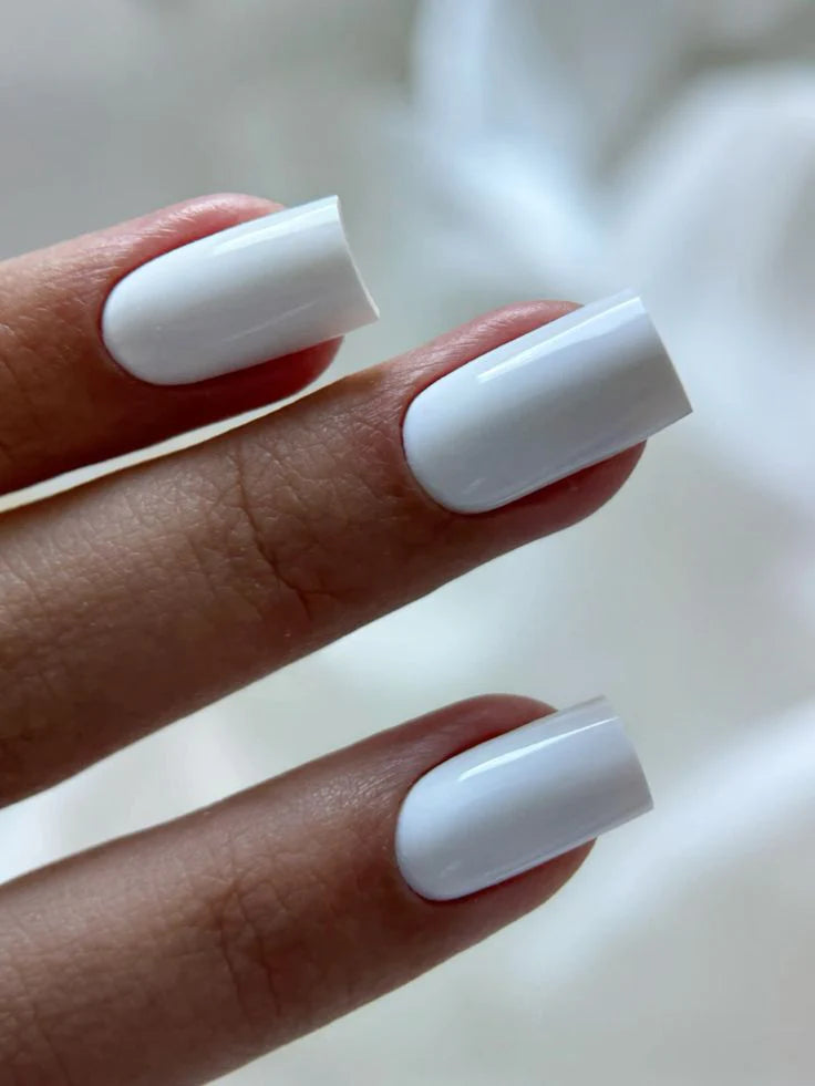 A close-up view of a professional square manicure featuring the opaque white Silcare Base One French White Opal UV builder gel shade by Silcare.