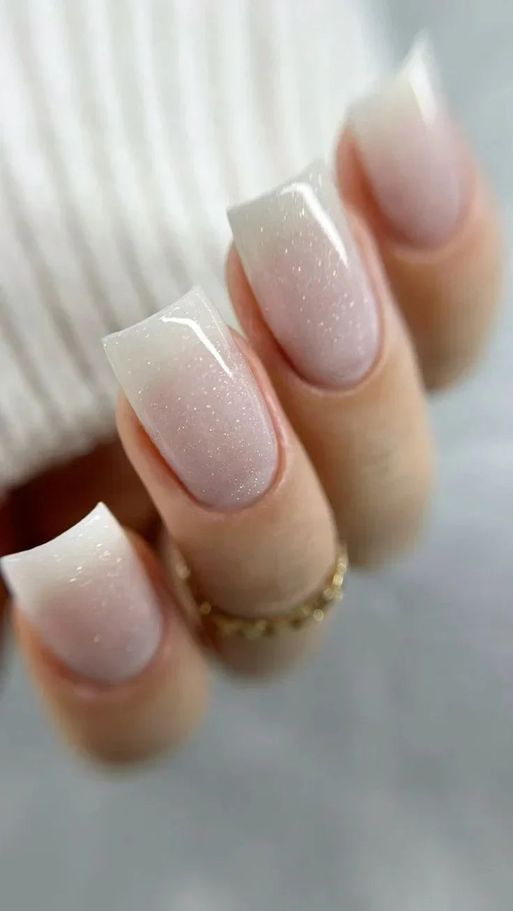 A professional manicure featuring square-shaped nails using Silcare Base One Builder Gel in Shimmer Milkshake, showing the milky white glitter effect.