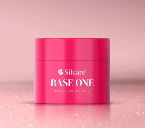 Shimmer Misty Rose Silcare Base One Builder UV Gel in bright pink jar packaging, placed on a soft sparkling pink surface with subtle glitter background, showcasing professional nail gel product with elegant shimmer aesthetic.
