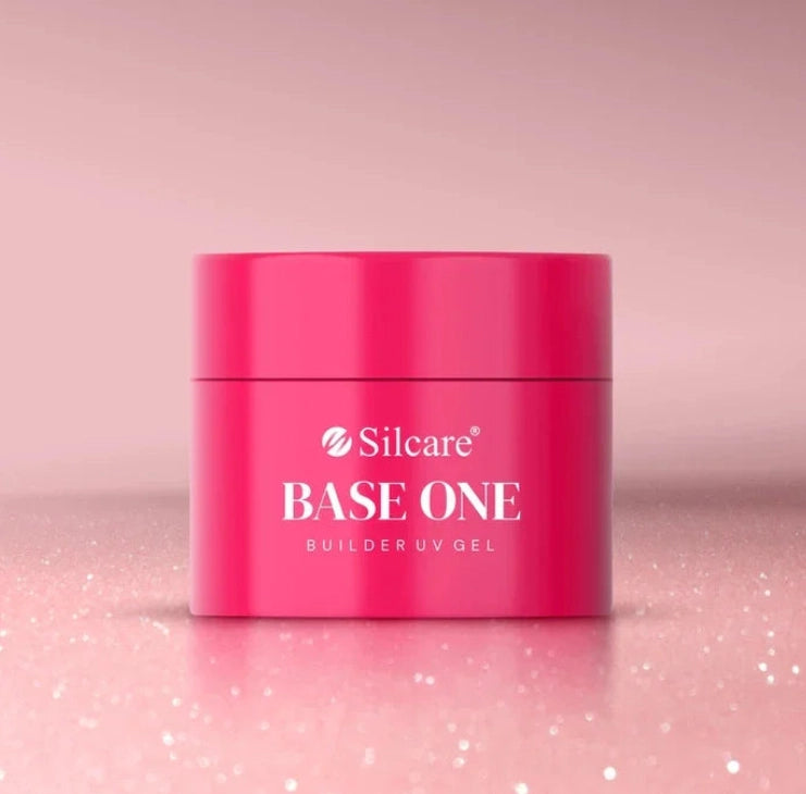 Shimmer Misty Rose Silcare Base One Builder UV Gel in bright pink jar packaging, placed on a soft sparkling pink surface with subtle glitter background, showcasing professional nail gel product with elegant shimmer aesthetic.