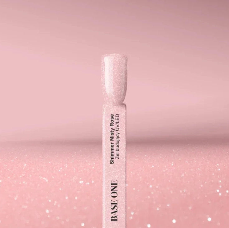 Shimmer Misty Rose Silcare Base One Builder UV/LED Gel swatch stick displaying a soft rosy pink shade with fine glitter shimmer, set against a matching sparkling pink background, highlighting glossy finish and delicate shimmer effect.
