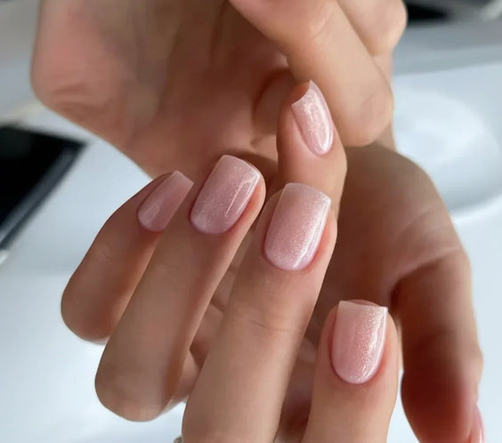 Close-up of short square manicured nails featuring shimmering pale pink Base One Builder Gel in Shimmer Vanillia Rose by Silcare.