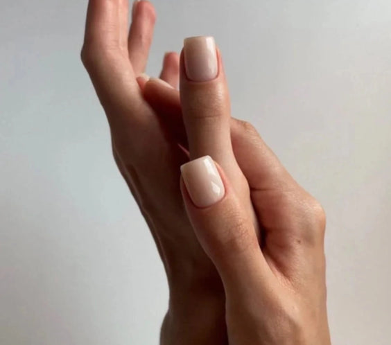 Silcare Base One Builder Gel Cover Light manicure on short square nails with creamy nude beige finish, shown on elegant hands against a minimal background, highlighting smooth coverage, natural nail look, and glossy salon-quality result.