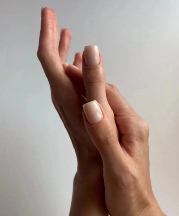 Silcare Base One Builder Gel Cover Light manicure on short square nails with creamy nude beige finish, shown on elegant hands against a minimal background, highlighting smooth coverage, natural nail look, and glossy salon-quality result.