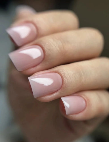 Close-up of hand with nude pink square-shaped nails created using Silcare Base One Cover builder gel, smooth glossy finish with natural coverage effect