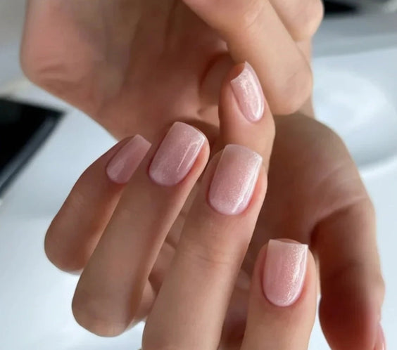 Close-up of short square-shaped nails finished with Silcare Base One Shimmer Vanillia Rose builder gel, featuring a soft milky blush pink shimmer, fine light-reflecting sparkle and a glossy self-levelling salon-quality finish for elegant natural-looking nails – Silcare Australia.