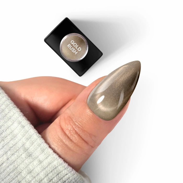 A long almond-shaped nail featuring Silcare maniMORE Gold Rush magnetic gel polish with a velvet cat-eye effect, shown next to the product bottle.